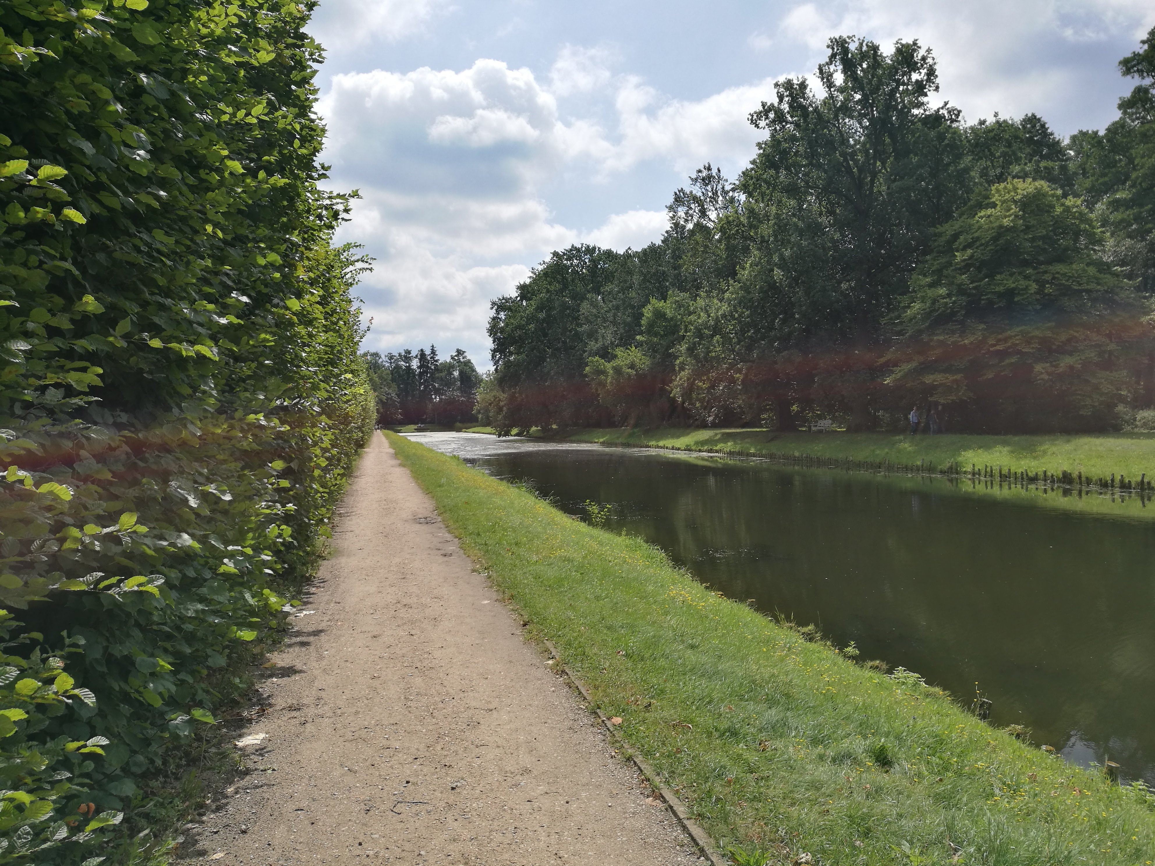On the left, a straight dirt path. On the right, a river.