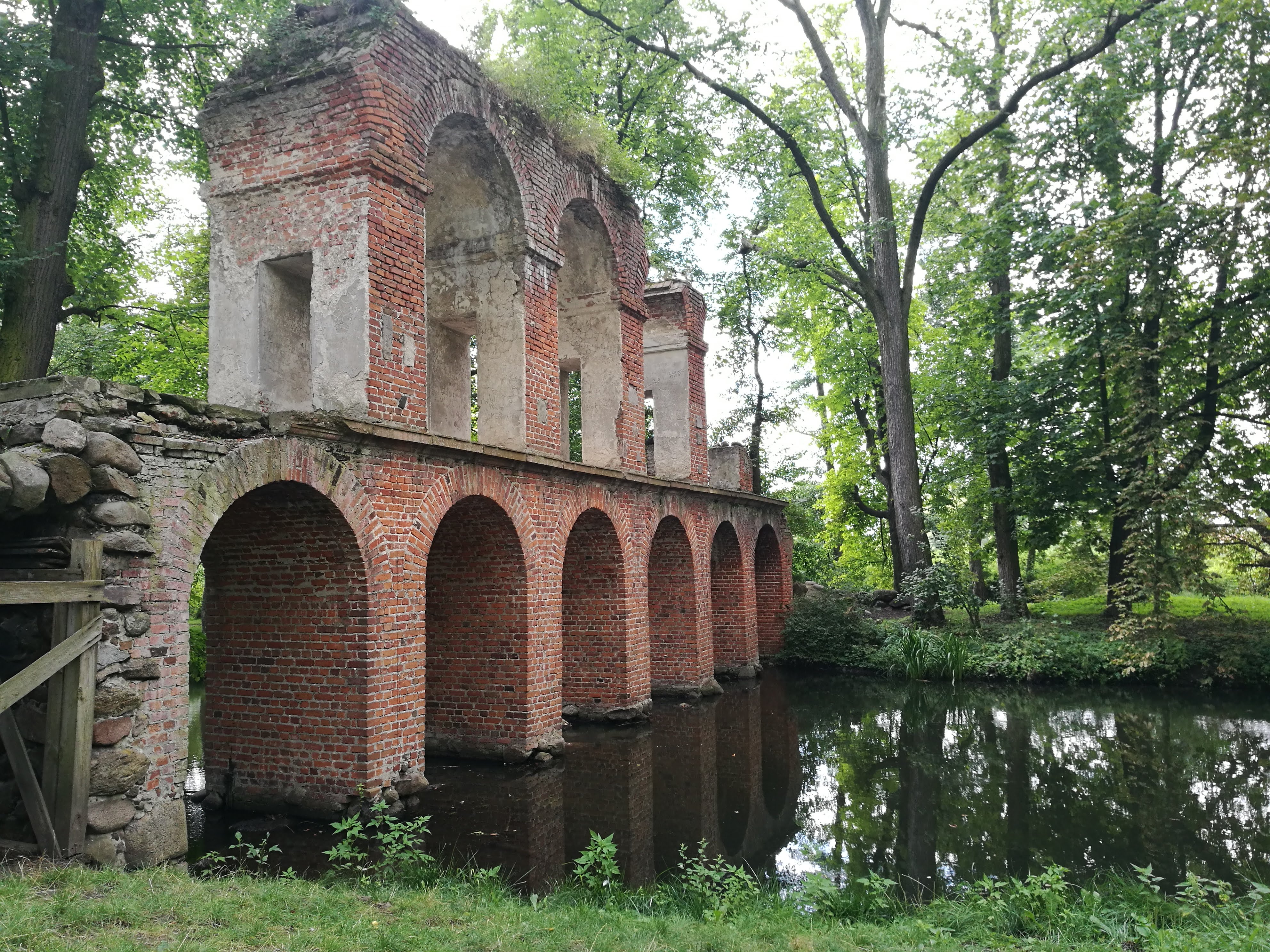A broken brick bridge crosses a river.