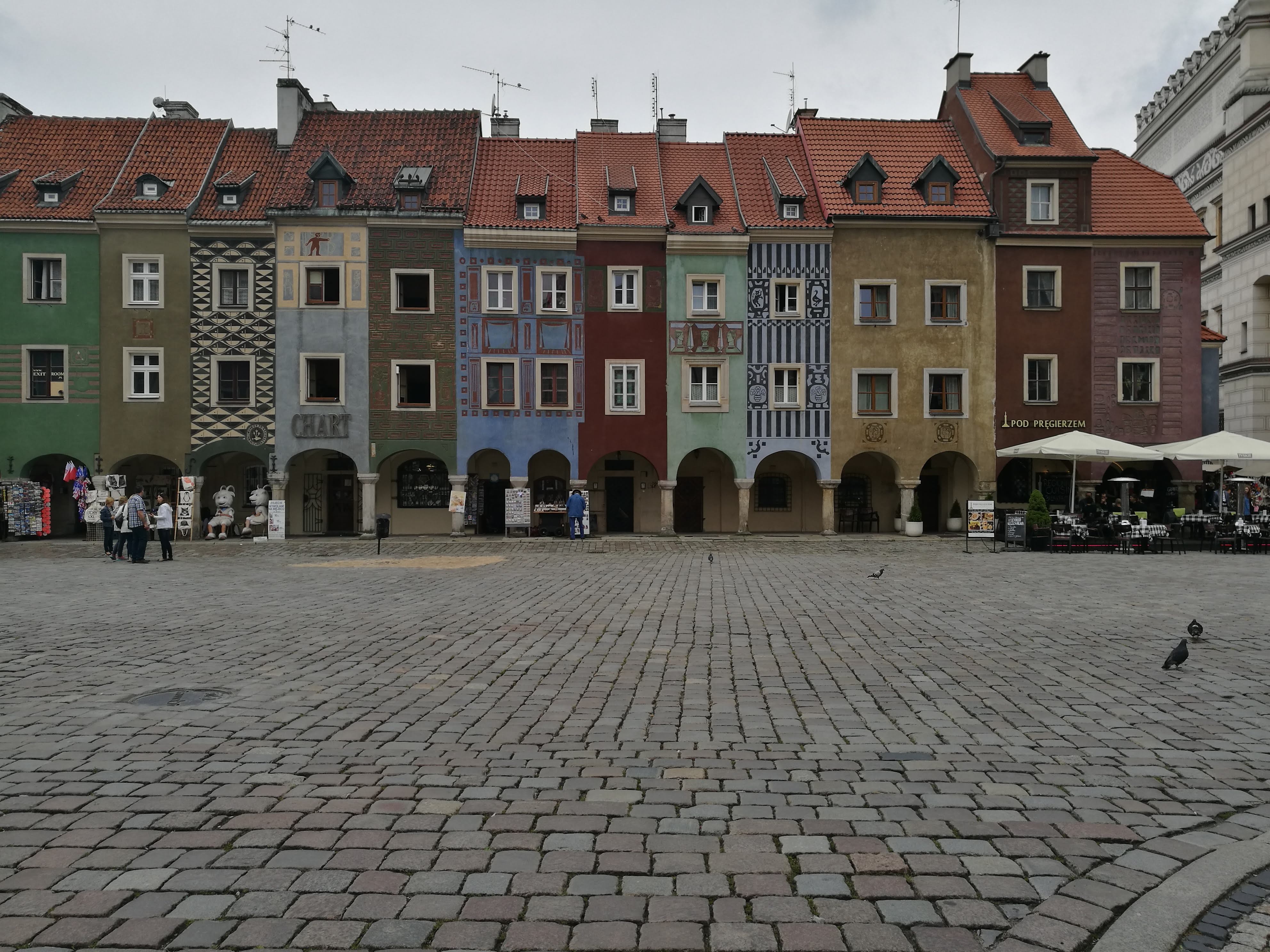 A large town centre square, with colourful buildings at the far end.