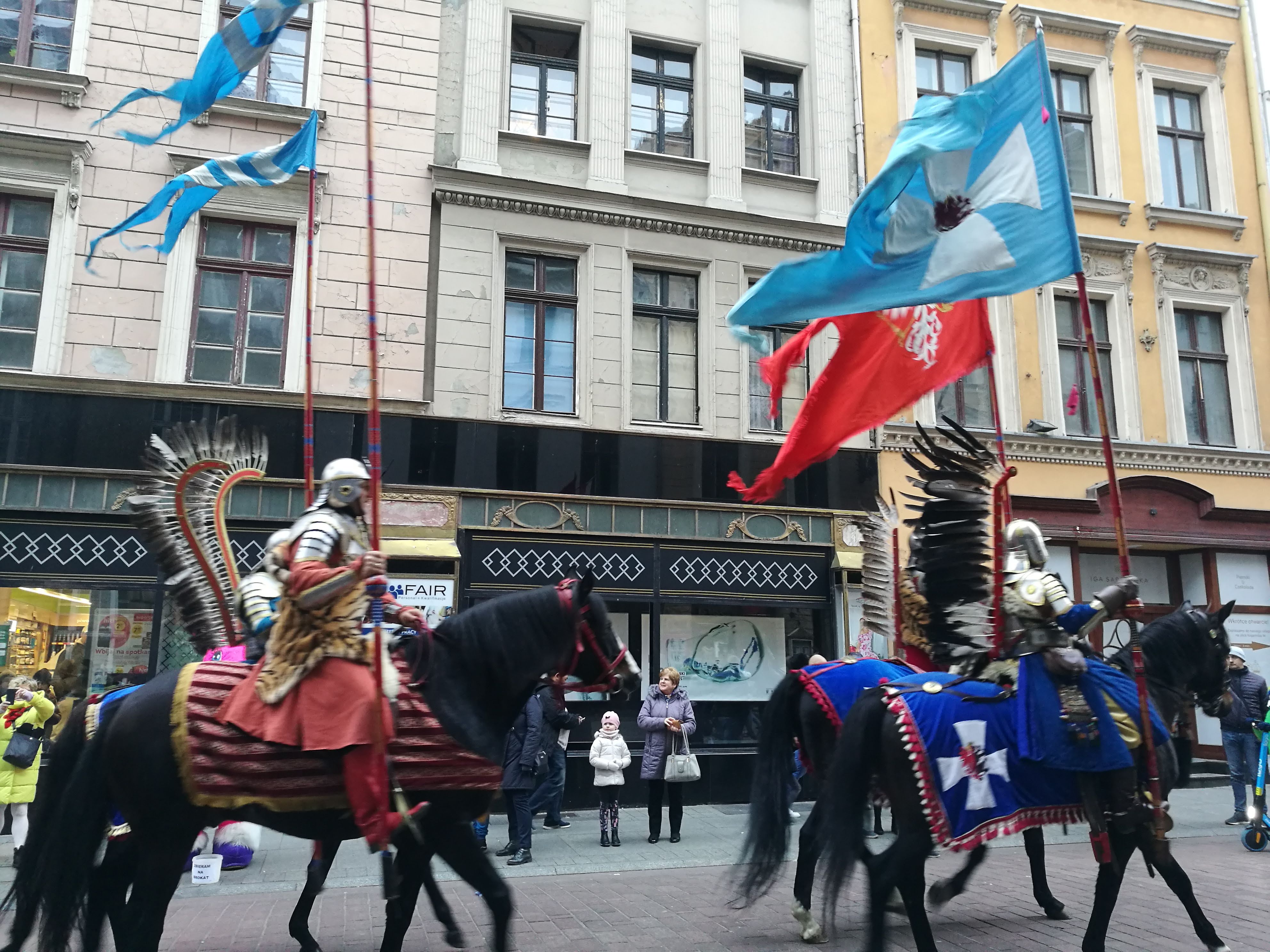 Horseback knights marching through a city